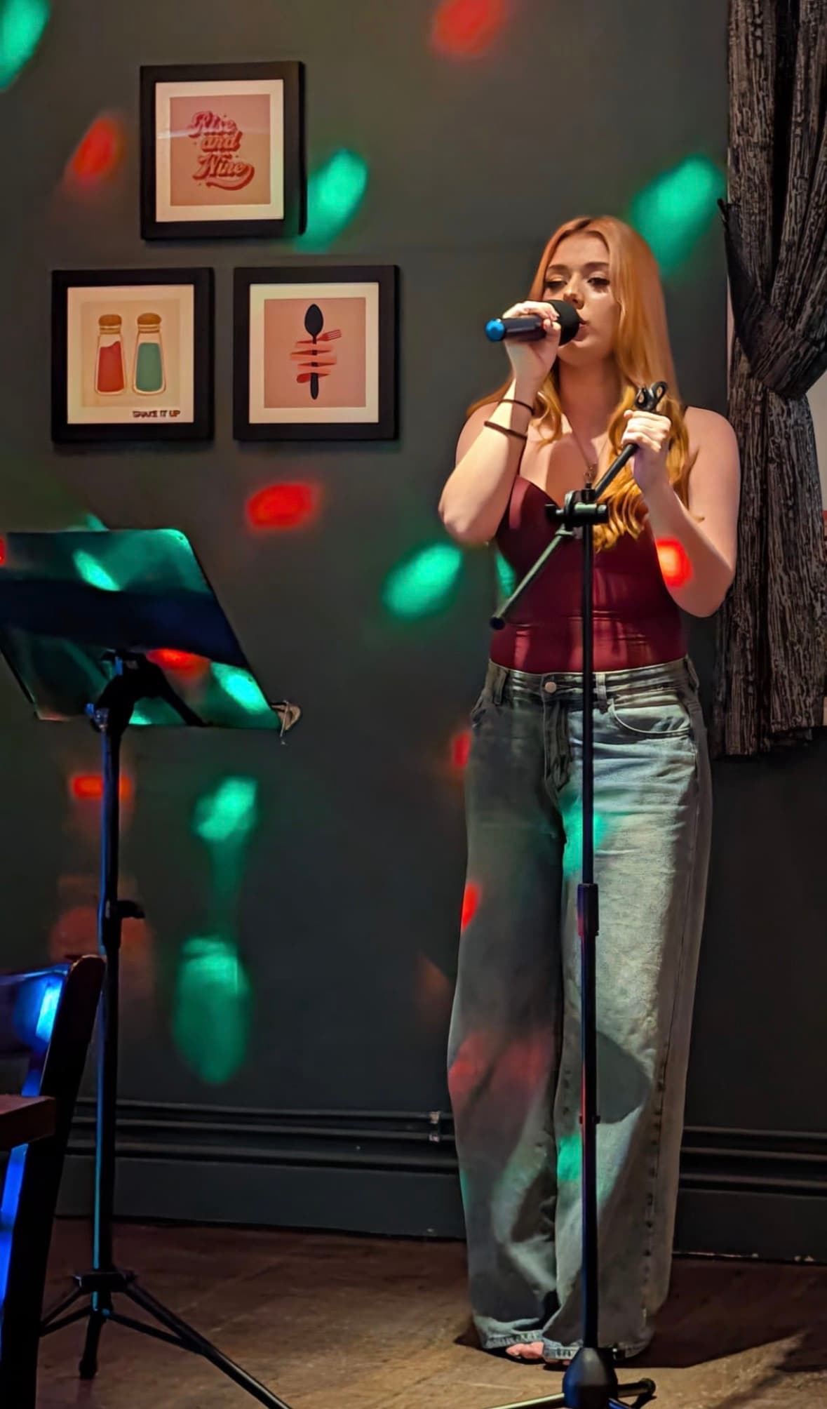 Abz performing under dramatic stage lighting with microphone in hand